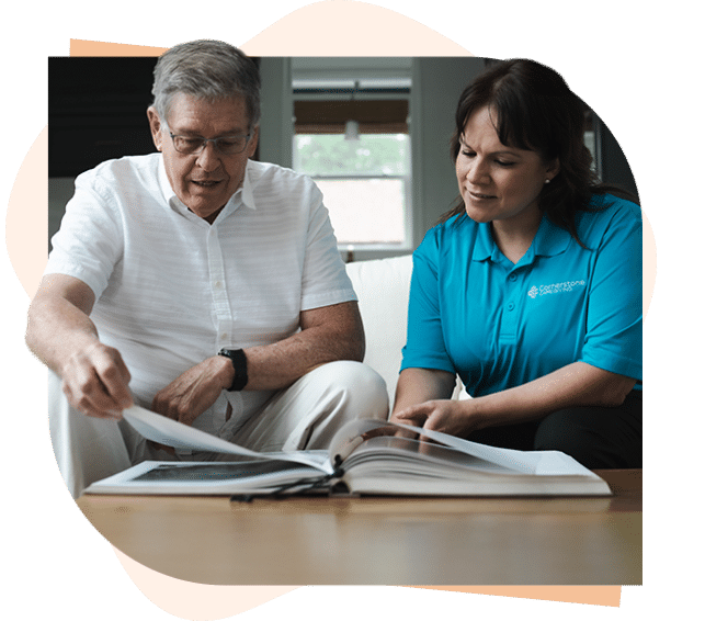 Senior client showing caregiver photos of his family