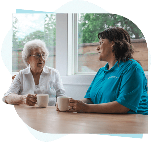 Senior client and caregiver having coffee together