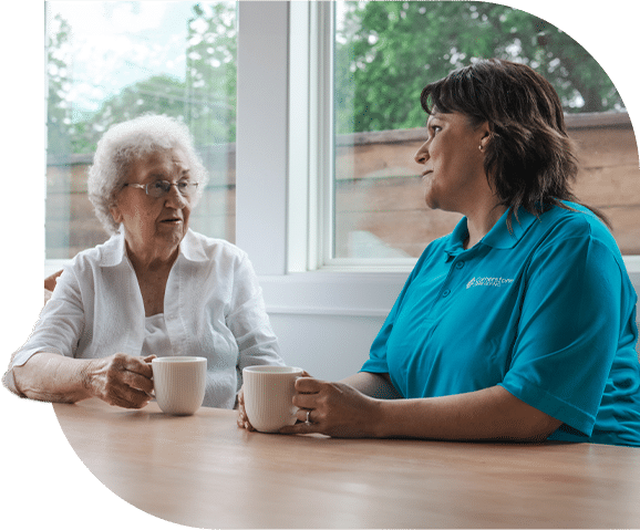 Caregiver and senior sharing a cup of coffee together