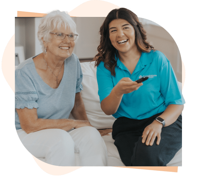 Caregiver and senior client watching tv together