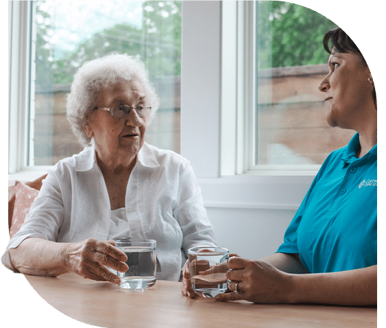 Senior client and caregiver drinking water together