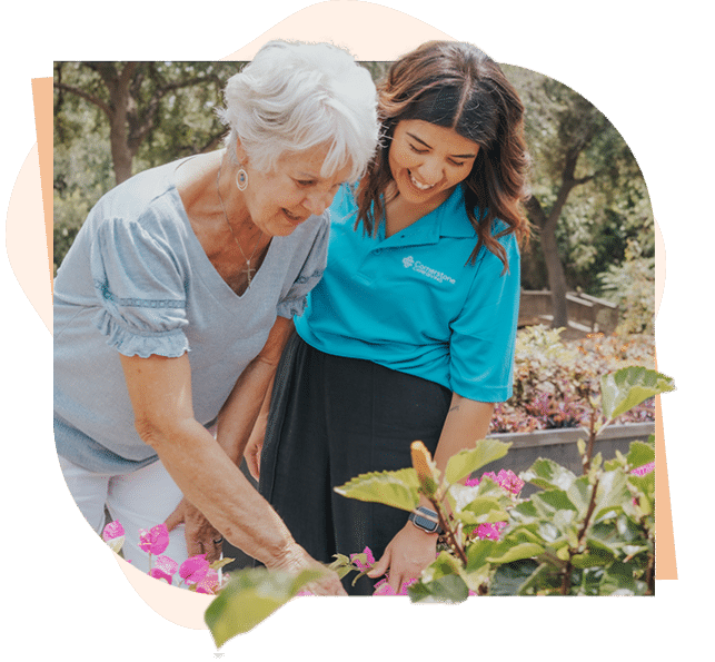 Caregiver and senior looking at flowers together