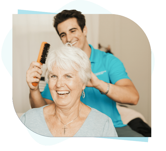 Caregiver brushing female seniors hair